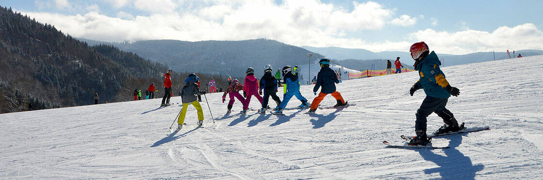 groupe d'enfants à ski sur une piste