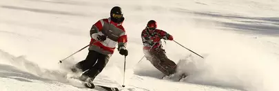 deux skieurs descendant une piste