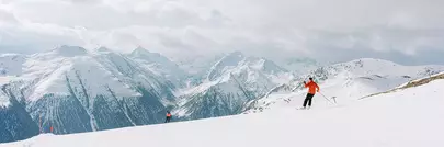 skieur seul face à un panorama de montagnes