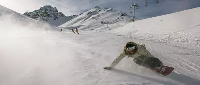 homme qui descend une piste en snowboard