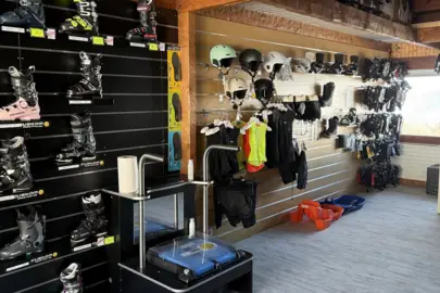Pashoek van de winkel Christina Sports in Arc 1600: wand met skischoenen, paspunt, helmen en slees voor kinderen