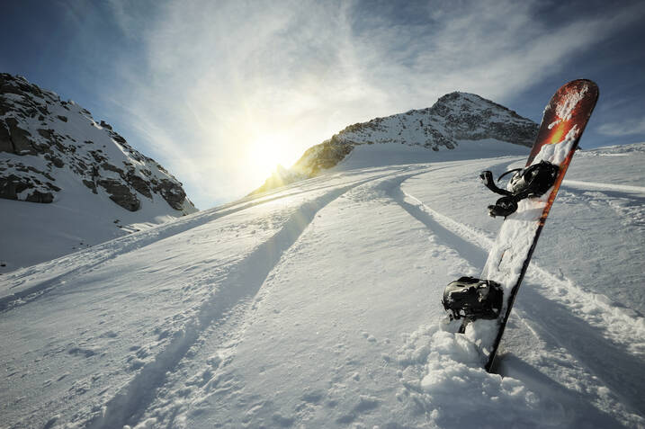 planche de snowboard dans la neige avec vue sur les sommets enneigés